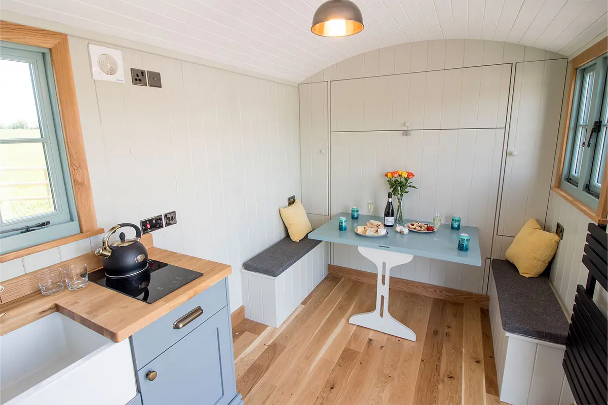 Interior photo of a shepherds hut with a table set up with food and drinks