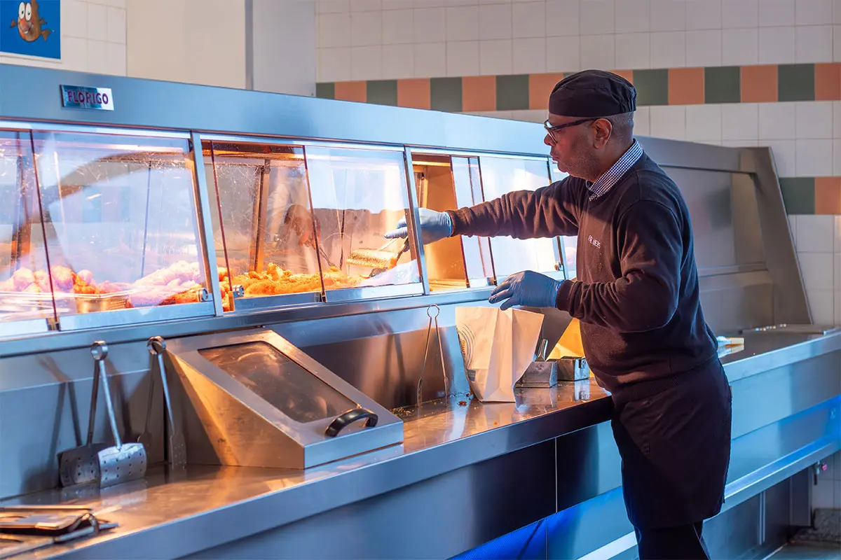 Staff member at Palmers Fish and Chips, serving food
