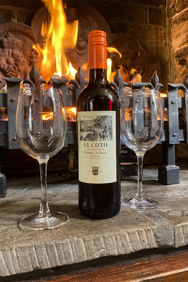 Bottle of red wine and 2 glasses in front of a roaring fire at The Royal Oak Over Stratton