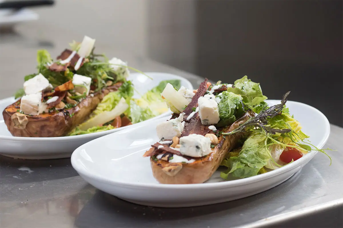 2 plates of Baked aubergine and salad with feta cheese in the kitchen at The Royal Oak Over Stratton