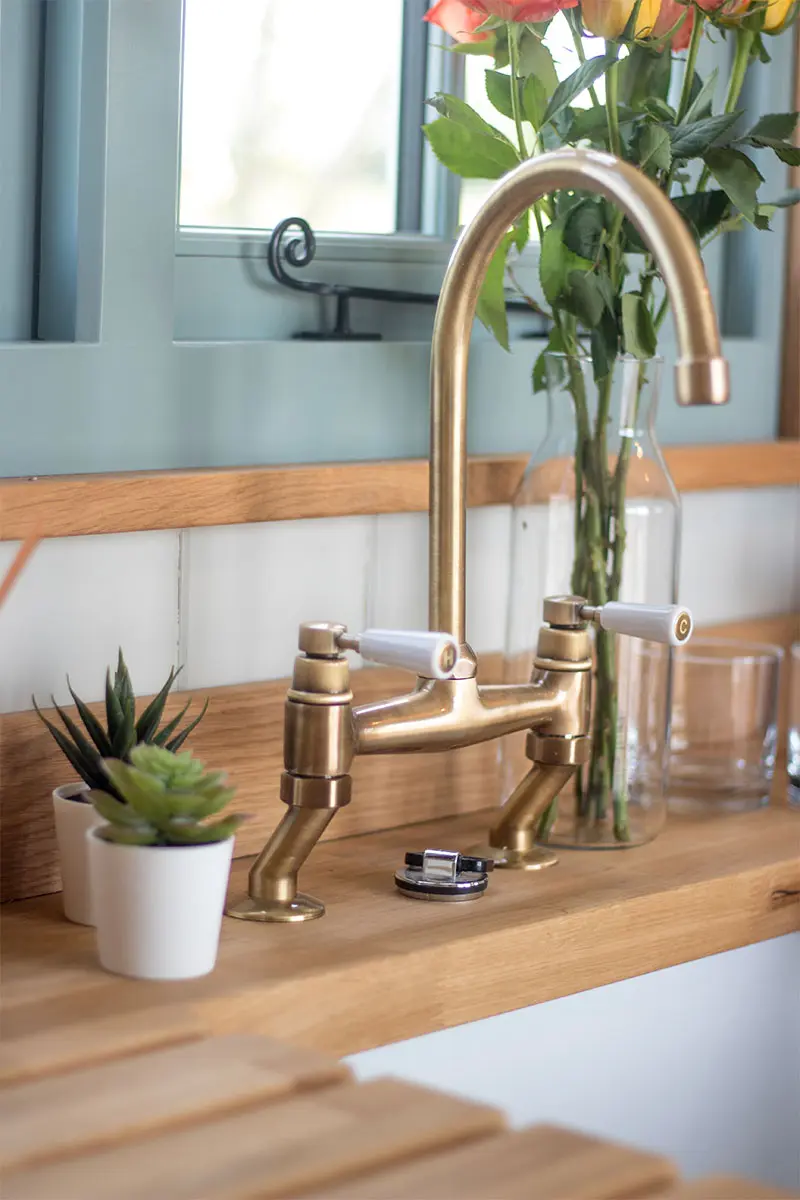 Bronze tap on a wooden worktop with a sink in a shepherds hut