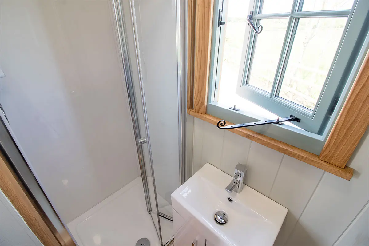 Somerset Shepherd huts bathroom in the shepherds hut, including a sink and shower