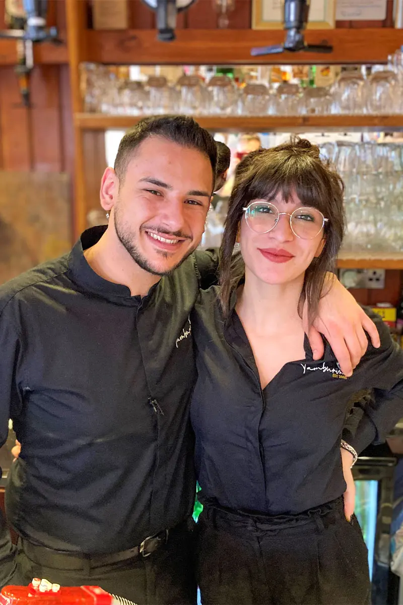 2 waiters smilling at Tamburinos in Street