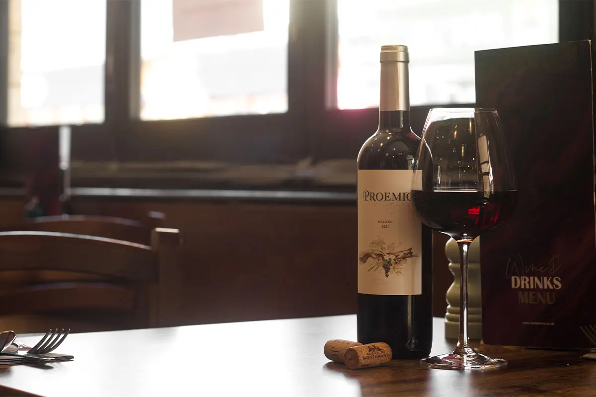 Glass full of Red Wine and red wine bottle on a table